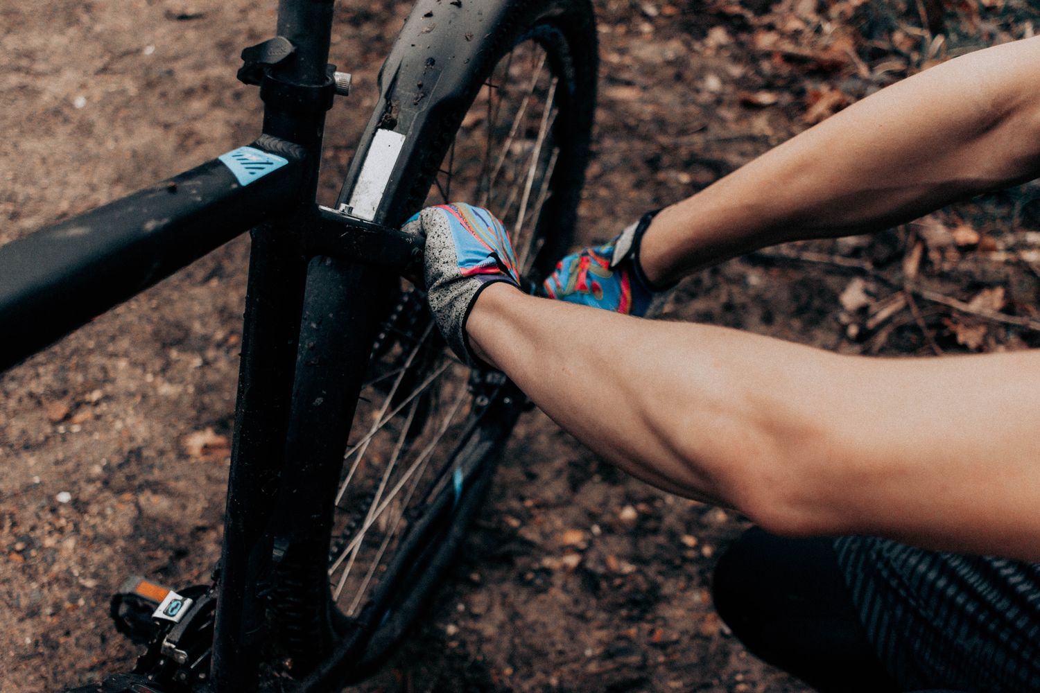 A person repairing a bicycle wheel outdoors