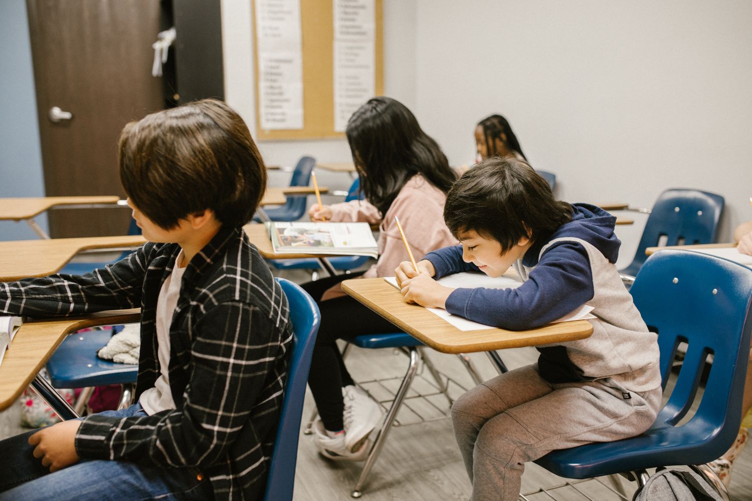 Students writing at their classroom desks